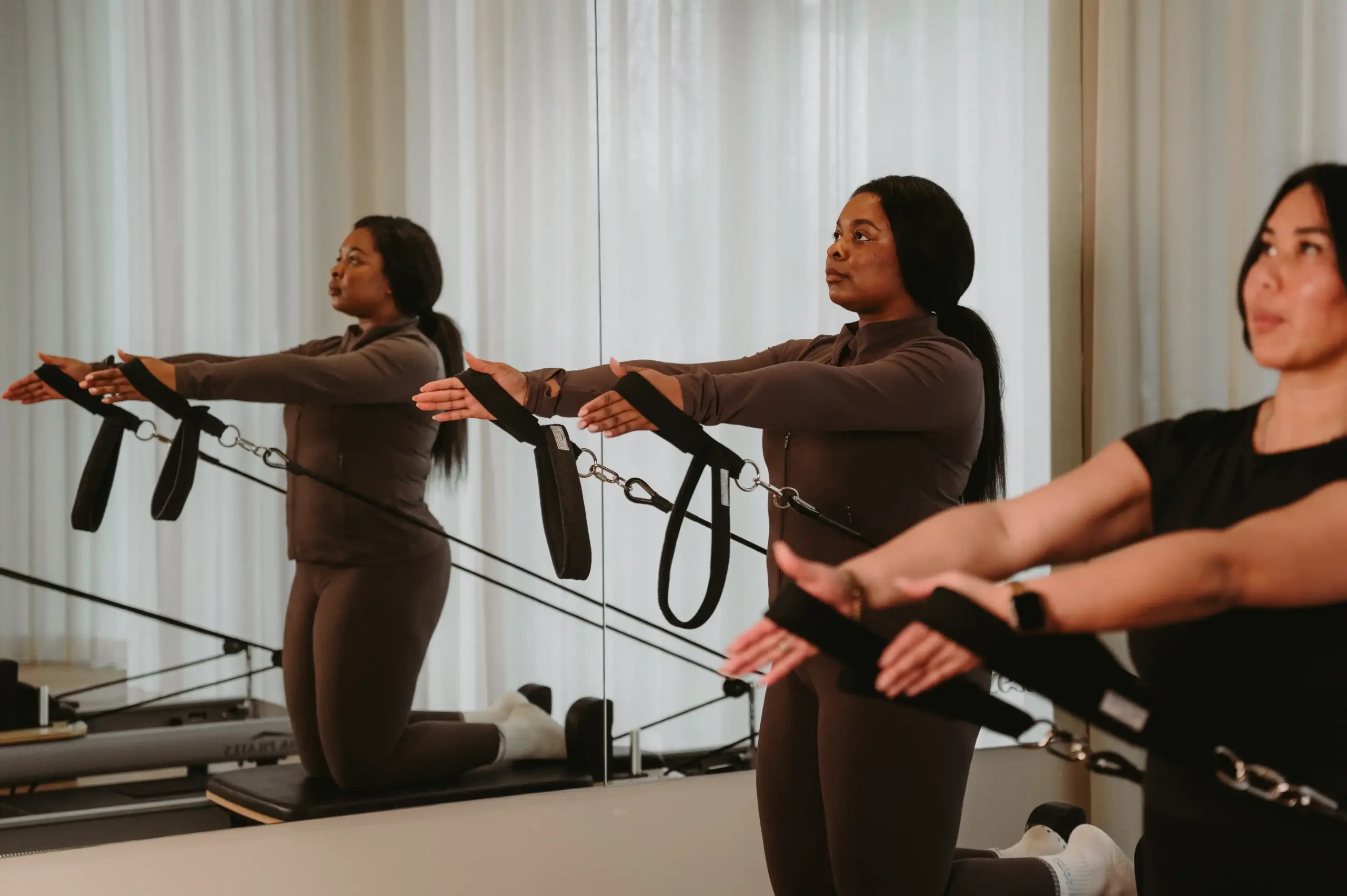 Close-up of reformer Pilates arm exercise showing proper form in Zen Zest Goes studio
